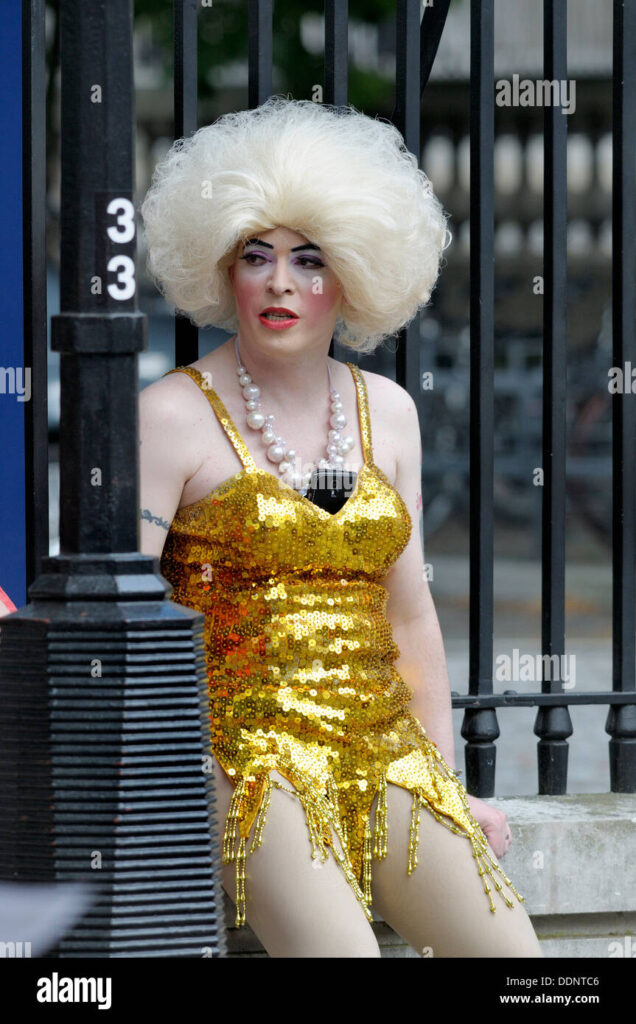 transvestite-dressed-in-gold-sequins-with-blond-wig-at-a-demonstration-DDNTC6